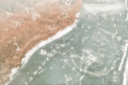 Winter Ice fishing on a frozen river - aerial shotの写真素材