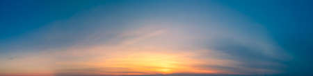 Panorama of blue sky with yellow sunset sun glareの写真素材