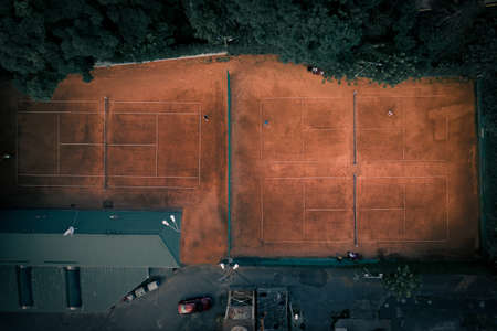 Clay Tennis courts among the green foliage in the city - top viewの写真素材