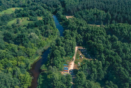 Tent Camp river green tourists on the river bank among the green forest - aerial shotの写真素材