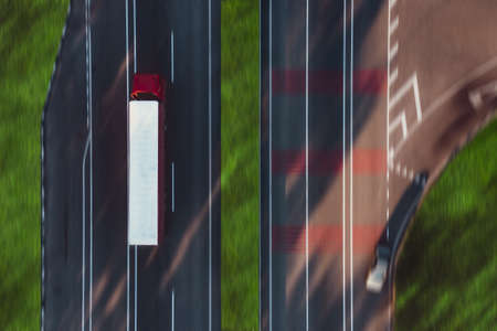 Truck on the road with left-hand traffic - aerial overhead view. Road transport delivery Concept.の写真素材