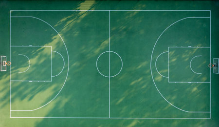 Green football field with white markings and morning shadows, top viewの写真素材