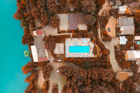 Luxury real estate on the shore of a azure pond, top view drone shot at fall seasonの写真素材