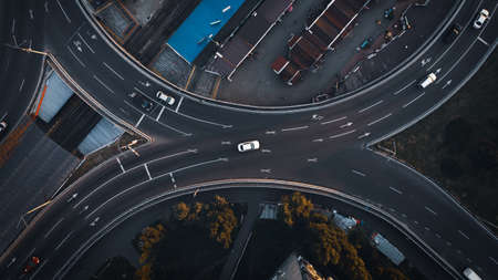 Top view aerial drone shot of asphalt road with cars in the evening cityの写真素材
