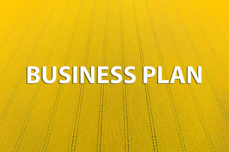 Business Plan Inscription on the background of the yellow sunflower field. Business plan for farmersの写真素材