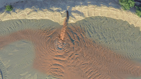 Spot rusty contamination from liquid flowing out of pipe, aerial drone shot, climate change conceptの写真素材