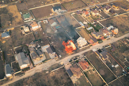 Fire in private house in the middle of private sector - aerial drone view shot.の写真素材