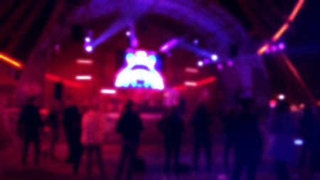 Dancing People at disco with neon rays of light and hologram. Concept of nightlife of young people.