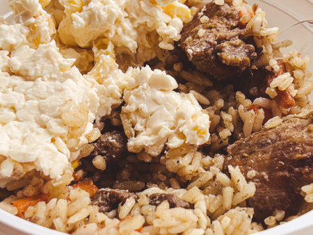 Street food: rice with meat and processed cheese: street pilaf in plastic dishesの写真素材
