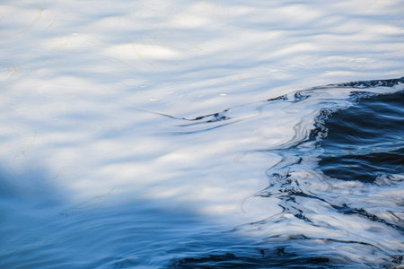 Abstract image of water with sun reflections creating a tranquil, rippled surface