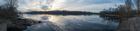 A breathtaking view of a wonderfully calm river at sunrise, capturing the stillness of the water and the vibrant colors of the sky, making it perfect for naturethemed projects and presentationsの写真素材