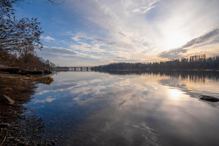 A stunningly beautiful river landscape reflecting the vibrant sky during a breathtaking sunset. The calm waters and the picturesque views together create a truly peaceful and serene atmosphereの写真素材