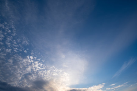 A truly peaceful sky filled with fluffy white clouds and warm, golden sunlight inspires creativity and sparks artistic ventures, encouraging the flow of boundless imagination and unique ideasの写真素材