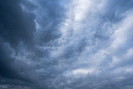 A captivating and mesmerizing view of turbulent, stormy overcast skies showcasing dynamic and intricate cloud formations, perfect for evoking a deep mood and atmospheric feelings throughout the sceneの写真素材