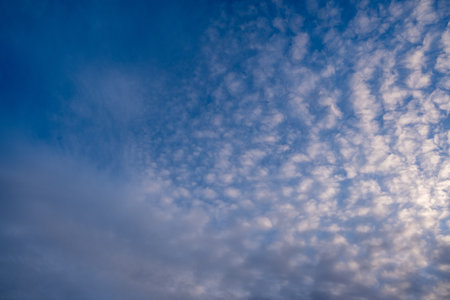 A breathtaking and stunning view reveals a vibrant blue sky adorned with delicate, artistically patterned clouds, perfectly capturing the tranquil beauty that defines a serene and picturesque sceneの写真素材