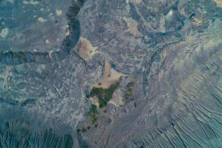 Top-down aerial view of a vast, desolate industrial spoil heap or slag dump. Abstract geomorphic pattern showing layered blue-gray textures, reflecting environmental pollution and damage.の写真素材