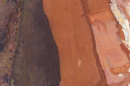 Drone shot capturing the strong organic boundary between dark, fuzzy soil and a warm, reddish-brown...