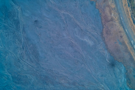 Aerial drone shot of a long straight defensive trench cutting diagonally through a field. Top down view of military earthworks, anti-tank ditch and infantry fortifications. War landscape texture. Border barrier concept.の写真素材