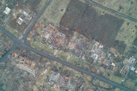 Aerial view of a road intersection in a ghost town, surrounded on all sides by burnt foundations and...
