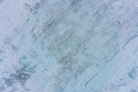 Hardened surface of the earth captured from above reveals a complex mixture of ice, snow, and dry...