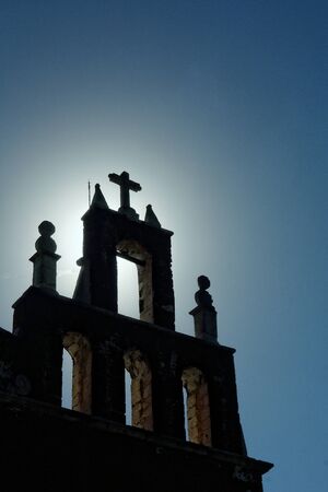 A backlit image of a Spanish colonial church in Yucatan. Mexico, blue sky, clouds, natural light, colorの写真素材