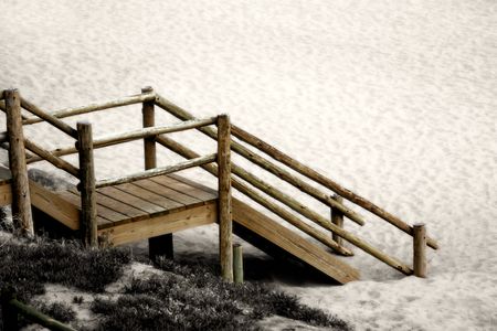 Wooden steps to the beach surrounded in sand and grass.の写真素材
