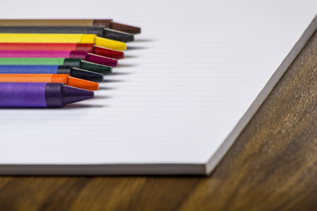 Various color crayons on white lined paperの写真素材