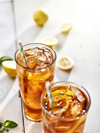 cold ice tea with sliced lemons and strawsの写真素材