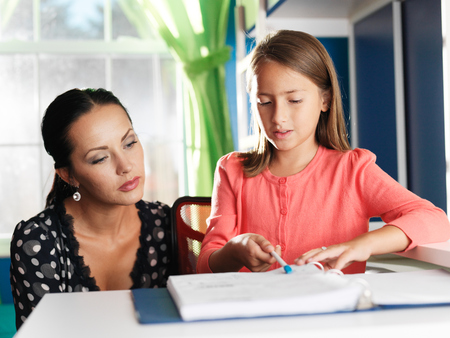 mother helping daughter with homeworkの写真素材