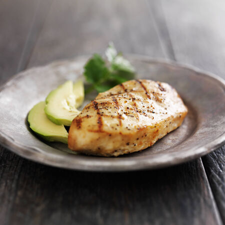 grilled chicken with cilantro and avocado on metal plateの写真素材