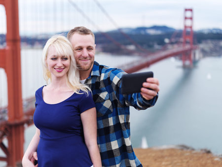 couple taking selfie in front of golden gate bridge at battery spencer