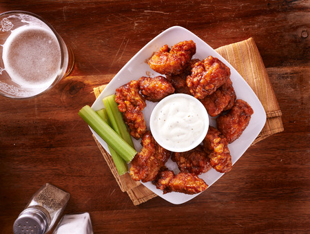 bbq buffalo chicken wings with beer ranch and celery shot top downの写真素材