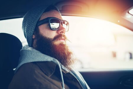 bearded hipster wearing sunglasses inside carの写真素材