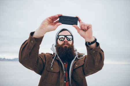 bearded hipster taking selfie in salt flats with retro tone