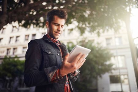 handsome man in down town los angeles using tablet on the goの写真素材