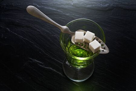 absinthe in pontarlier glass and spoon with sugar cubesの写真素材