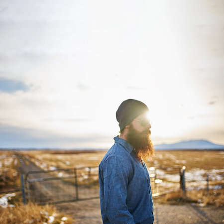 bearded man wondering around the middle of nowhere in nevada at sunset