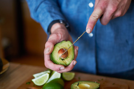 man cutting avocado to use in making guacamole