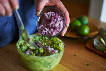 making guacamole and mixing in onionsの写真素材