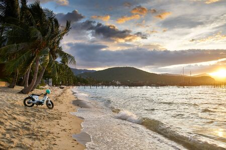 vintage motorbike on koh samui beach in thailand at sunsetの写真素材