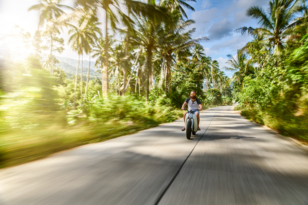 driving vintage motorbike fast through country side in thailandの写真素材