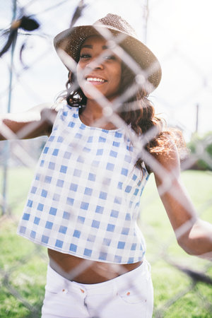 Woman Wearing Sunhat While Standing Behind Fence