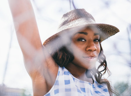 Woman Wearing Sunhat While Standing Behind Fenceの写真素材
