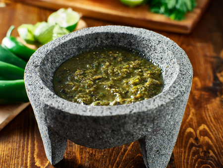 mexican salsa verde in traditional stone molcajeteの写真素材