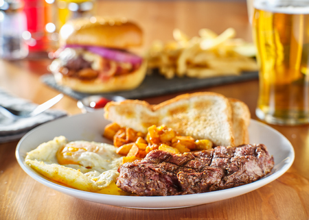 steak and eggs breakfast with toast and homestyle potatoes in restaurantの写真素材