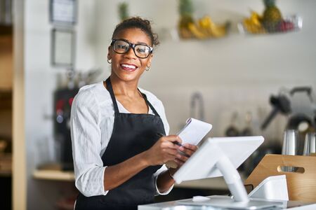 smiling waitress ready to take down order at restaurant counterの写真素材