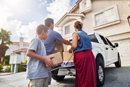 hispanic family unloading pickup truck and moving into new house in las vegasの写真素材