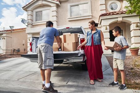 hispanic family unloading pickup truck and moving into new house in las vegasの写真素材