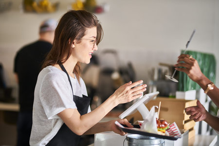 waitress handing order of food on tray to customer
