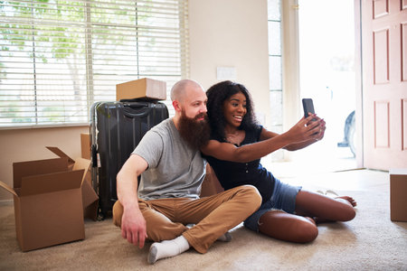 interracial couple taking selfie together while moving into new home